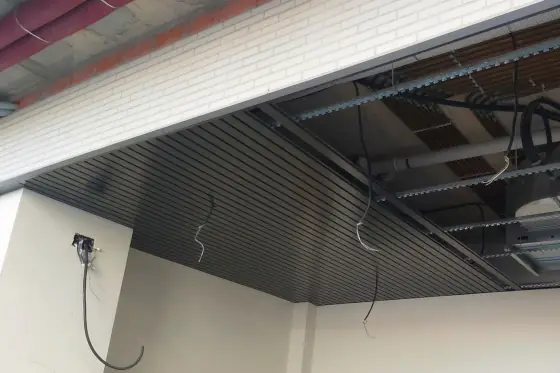 Falso techo metálico de lamas instalado en interior de edificio