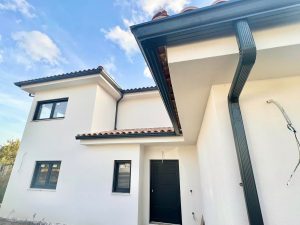 Instalación de canalones de aluminio y bajante pluvial en vivienda unifamiliar