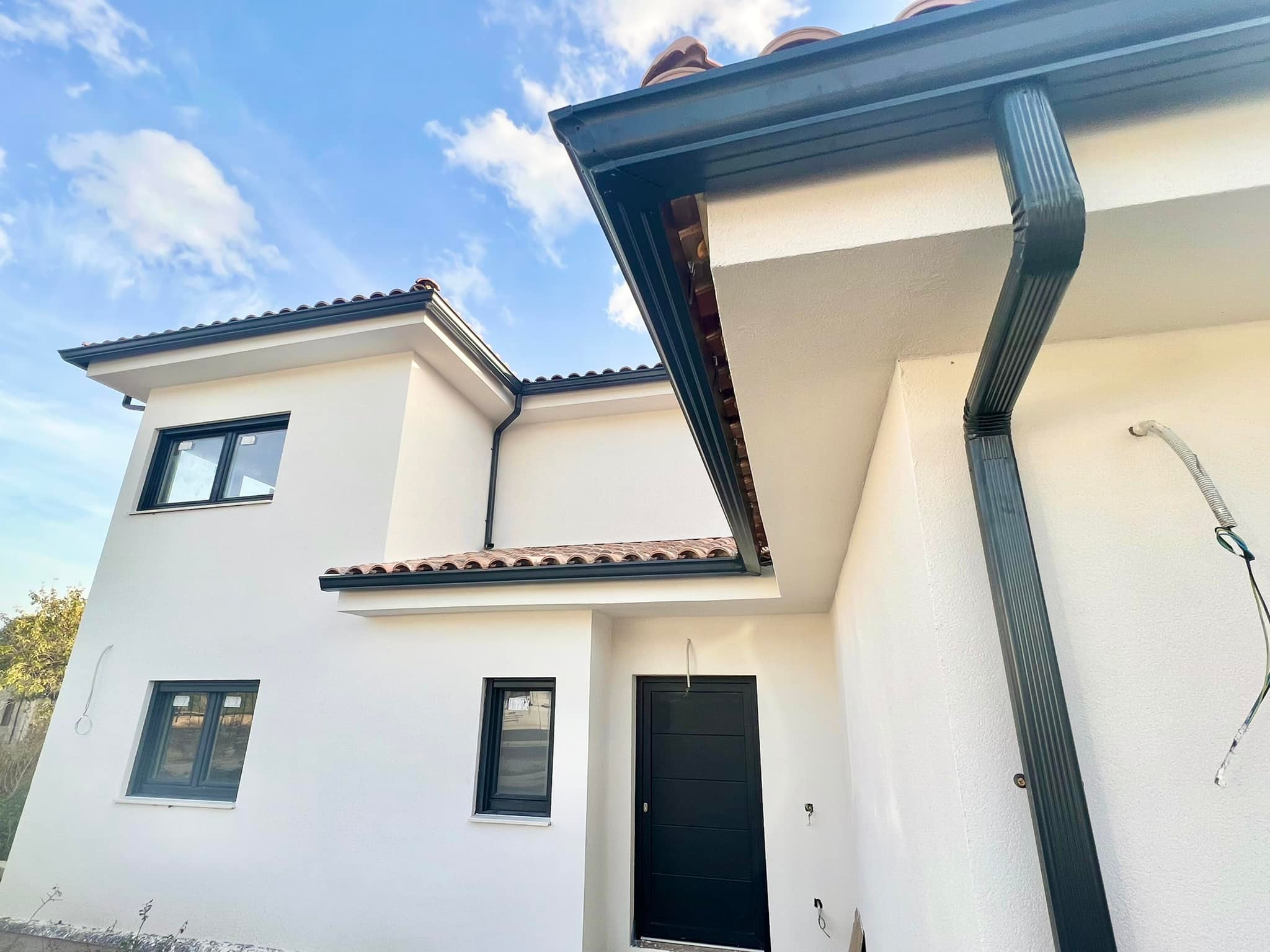 Instalación de canalones de aluminio y bajante pluvial en vivienda unifamiliar