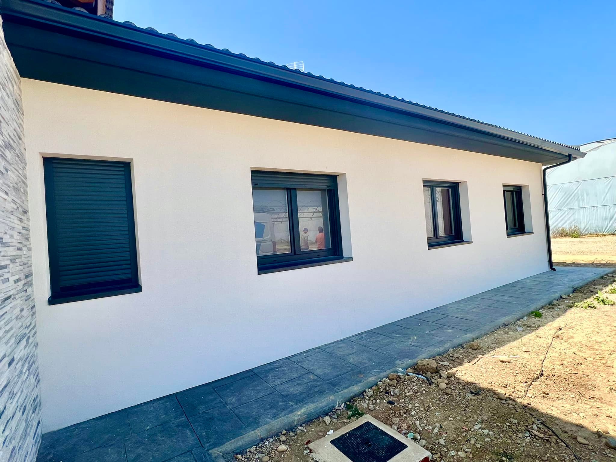 Vista de canalones de aluminio, bajante pluvial y vierteaguas de ventana en una vivienda