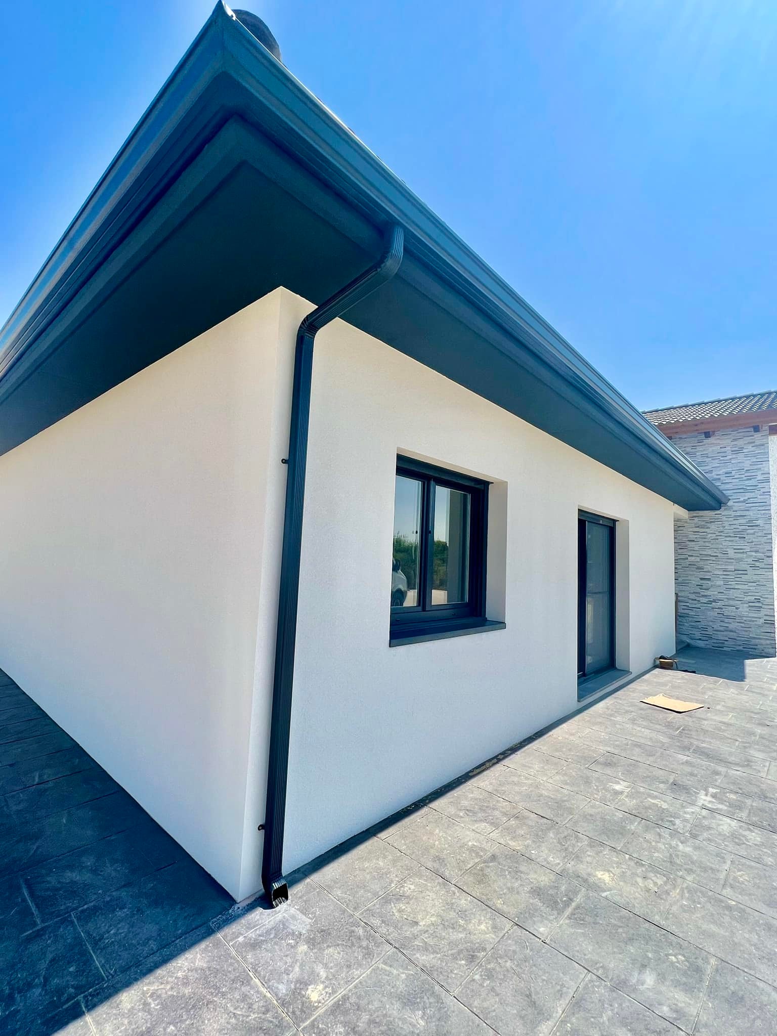 Detalle de la bajante pluvial y vierteaguas de ventana